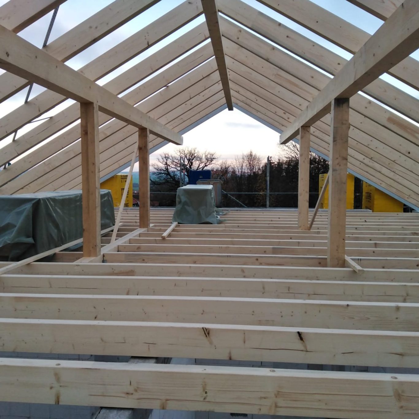 Gerichteter Dachstuhl mit Konstruktionsvollholz, unvollständig, Blick auf den Himmel und die Umgebung.